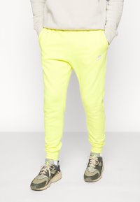 Nike Sportswear CLUB JGGR - Tracksuit bottoms - yellow strike