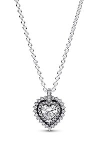 Strieborný reťazový náhrdelník s veľkým srdcovým príveskom obklopeným menšími kameňmi, pričom v strede sa nachádza jasný diamant.