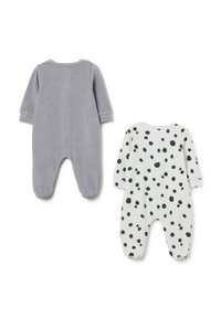 Dos peleles para bebés: uno gris, hecho de una tela suave, y uno blanco con lunares negros. Ambos tienen mangas largas y diseño con pies.
