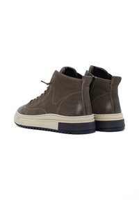 Donkerbruin leren hoge sneakers met crèmekleurige rubberen zolen en marineblauwe accenten, met een gladde afwerking en versterkte stiksels.
