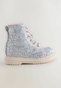 Bottine argentée scintillante avec une surface texturée, des accents roses, des œillets métalliques et une semelle blanche épaisse.