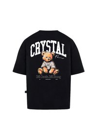 Černé oversized tričko s grafikou medvídka na zadní straně, s nápisem "CRYSTAL Paris" a dalším textem pod ním. Bavlněný materiál.