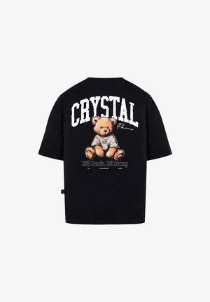T-shirt noir surdimensionné avec un graphique d'ours en peluche au dos, accompagné de "CRYSTAL Paris" et d'un texte additionnel en dessous. Matière en coton.