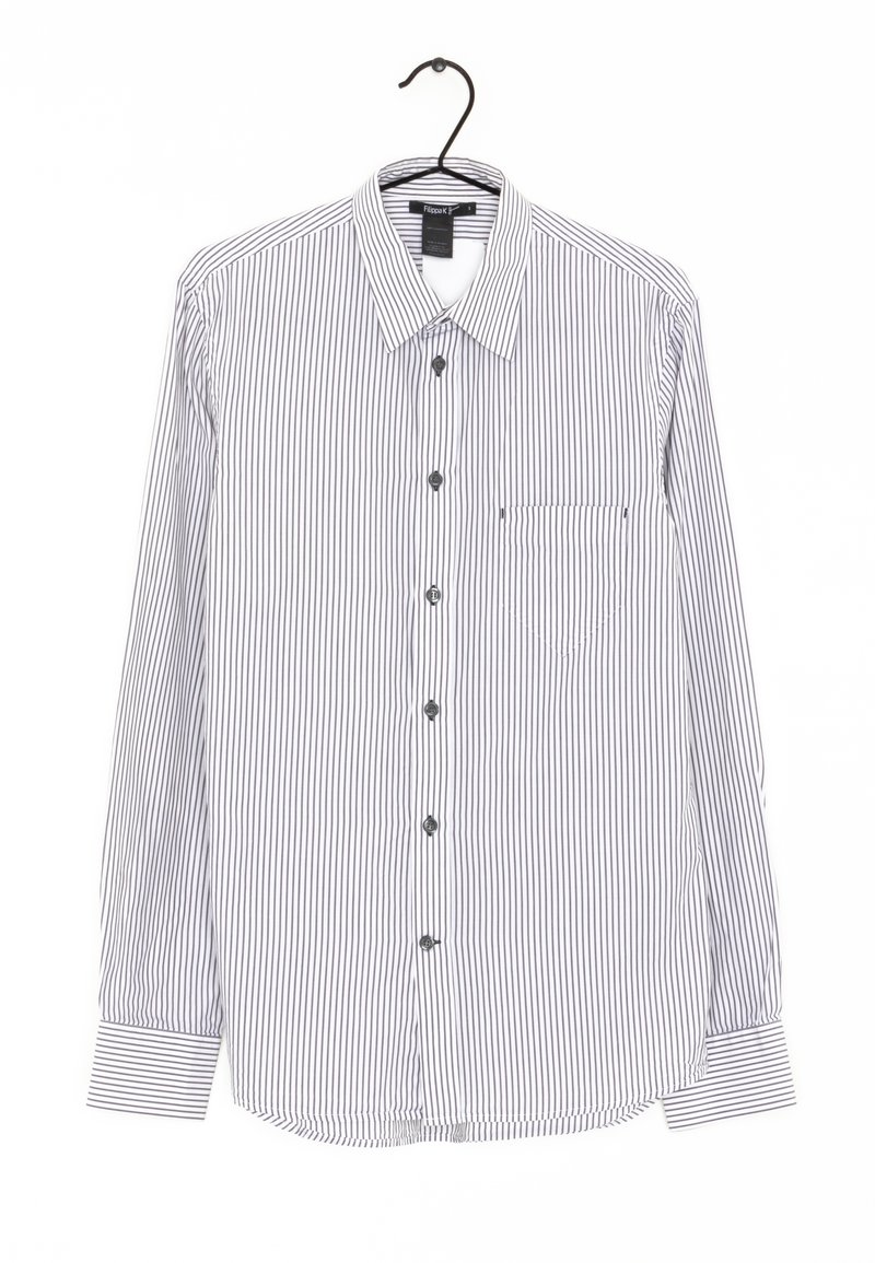 Långärmad skjorta med knappar i vitt med marinblå vertikala ränder. Har en spetsig krage, bröstficka och rundad nederkant. Tygtexturen verkar slät.