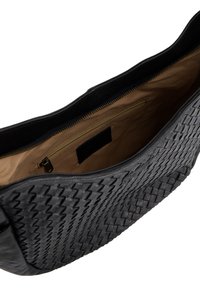 Schwarze Lederhandtasche mit gewebter Textur, Reißverschlussverschluss und einem beige gestreiften Innenfutter. Das Innere verfügt über eine kleine Reißverschlusstasche.
