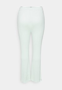 Calças caneladas de um verde menta claro, com uma cintura ajustada e bainha larga. O material parece elástico e possui uma textura suave. Sem ferragens visíveis.