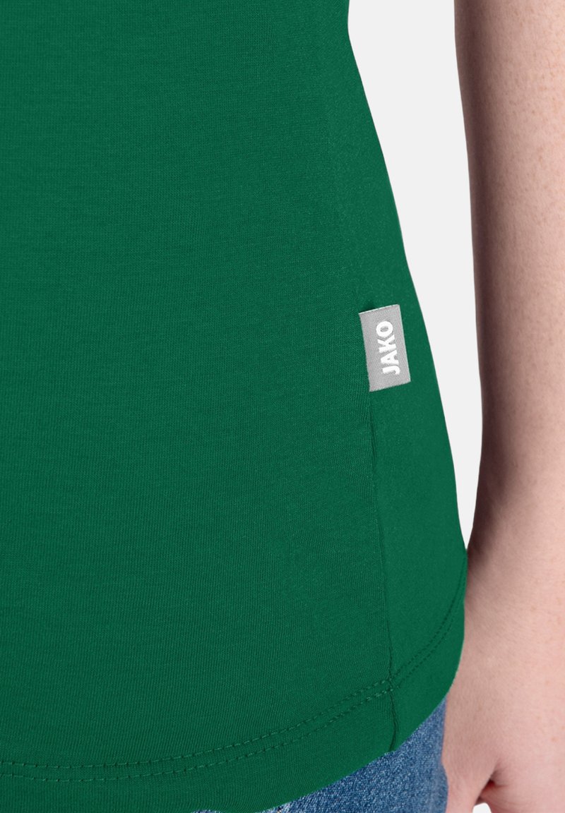 T-shirt in cotone verde con tessuto testurizzato; presenta un'etichetta JAKO sul lato della cucitura e un orlo curvo. Design semplice e aderente.