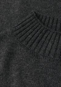 Mørkegrå strikket sweater med ribbet krave og tekstureret stof, der har en blød overflade og en løs, afslappet pasform.
