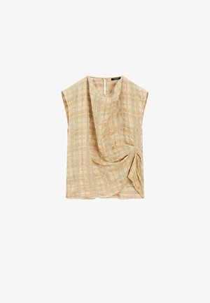 Haut beige à manches courtes avec une coupe décontractée, présentant un design tissé texturé et un drapé prononcé. Le dos dispose d'une ouverture en forme de clé avec un bouton.
