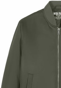 Blouson aviateur vert olive avec fermeture éclair à l'avant, col côtelé et une seule poche latérale visible.