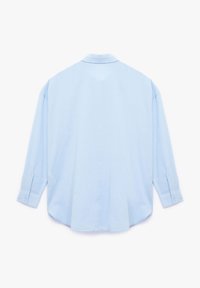 Light blue long-sleeve shirt with a relaxed fit, soft texture, pointed collar, and buttoned cuffs. Plain fabric without patterns.