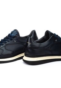 Mornarske kožne tenisice s teksturiranom površinom, kontrastnom bijelom međupjenu, tamnoplavim vezicama i suptilnim brendingom na peti.