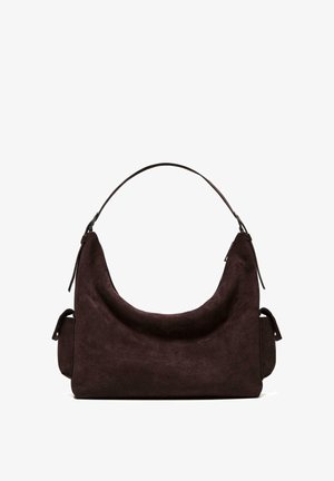 Tmavohnedá semišová kabelka hobo s jedným ramenným popruhom a bočnými vreckami na zips na jednoduchom bielom pozadí.