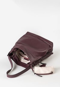 Borsa a spalla in pelle bordeaux scuro aperta, con una pochette interna a motivo beige, tasche con zip e tracolla regolabile su sfondo bianco.