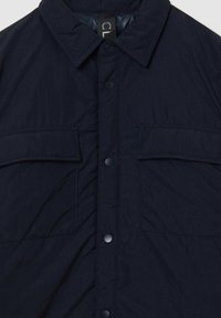 Giacca camicia imbottita blu navy con colletto, due tasche sul petto, chiusura a bottoni automatici e finitura in tessuto testurizzato.
