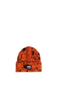 Gorro de punto naranja con motas negras, con puño doblado y una etiqueta negra con texto blanco. Textura suave, diseño de parte superior redondeada.