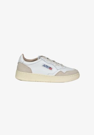 Sneakers bianchi in pelle con accenti in suede beige, punta rotonda e suola in gomma robusta. Presentano un design perforato e un'etichetta blu sul lato.