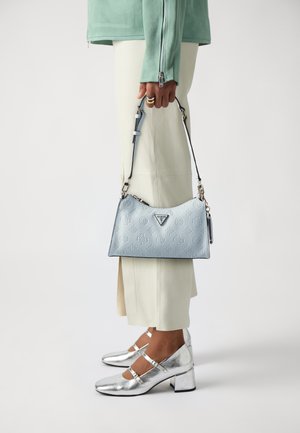 Borsa in pelle azzurro chiaro con motivo a logo impresso, forma appuntita e tracolla removibile; abbinata a scarpe con tacco cubico argentato.