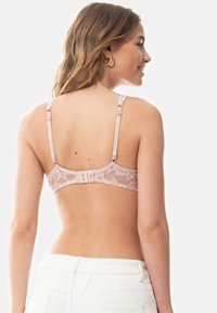 Podprsenka s krajkovým zadním dílem v jemně růžové barvě má nastavitelné popruhy a zapínání na háček a oko. Krajka má květinový vzor a hladký základní materiál.