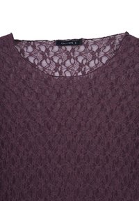 Top in pizzo bordeaux con scollatura rotonda. Presenta motivi floreali intricati su tutta la superficie e una texture leggermente trasparente. Etichetta del marchio visibile.