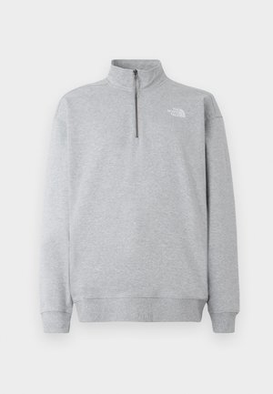 Grå sweatshirt med høj krave, frontlynlås og ribstrikkede manchetter. Har et lille, hvidt logo på venstre bryst. Blød stofstruktur.