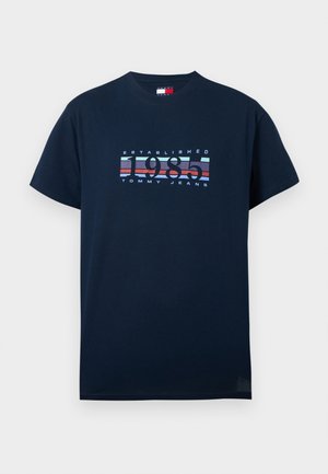 Marineblaue T-Shirt mit kurzen Ärmeln, auf der Brust mit dem Text "Established 1985 Tommy Jeans" und einem rot-weiß-blau gestreiften Motiv.