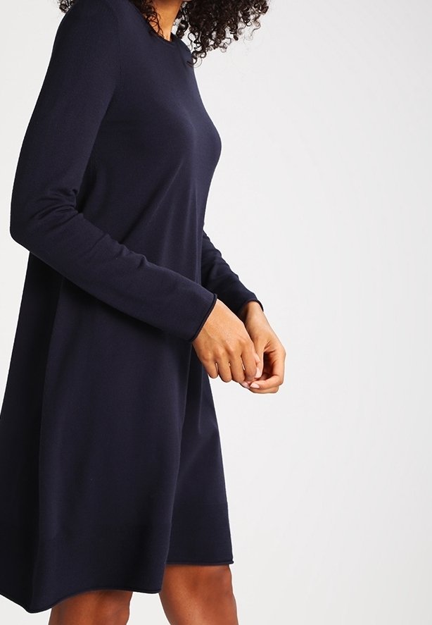 Abito lungo navy a maniche lunghe con scollatura tonda, silhouette a trapezio, texture morbida e design senza cuciture, che arriva a metà coscia. Nessun motivo o hardware visibile.