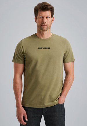 T-shirt olive vert à manches courtes en tissu texturé, avec un logo noir "PME LEGEND" centré sur la poitrine.