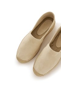Espadrillas in suede beige con punta rotonda, bordatura in corda di juta e suola piatta. Texture liscia con un design semplice e minimalista.