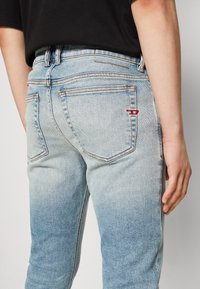 Ljusblå denimjeans med en urtvättad design, femfickstyle och orange sömmar. Har en liten röd logotyp på bakfickan.