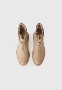 Beige ankle boots made of smooth leather with a textured upper, zipper closure, and decorative stitching around the collar.