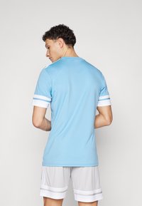 Light blue athletic t-shirt with short sleeves, featuring white stripe accents on sleeves and a rounded neckline.