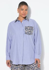 Camicia a maniche lunghe con strisce verticali blu e bianche, tasca con motivo leopardato e colletto a stampa leopardata a contrasto.