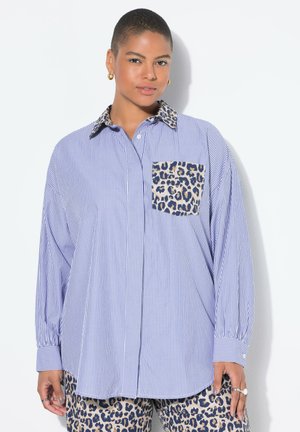 Chemise à manches longues avec des rayures verticales bleues et blanches, une poche à motif léopard et un col à imprimé léopard contrastant.