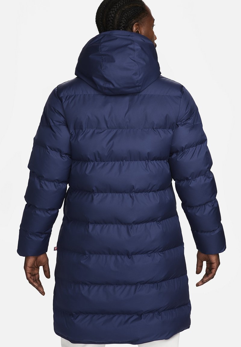 Marineblauer Puffercoat mit Kapuze, ausgestattet mit einem gesteppten Design, langen Ärmeln und einem mittellangen Schnitt. Die Außenseite hat eine glatte, glänzende Textur.