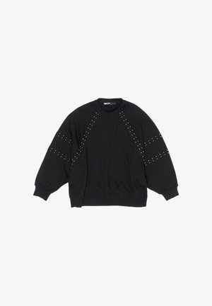 Melnā sporta džempera ar garām, plašām piedurknēm, uz pleciem un sāniem rotāta ar sudraba kniedēm. Izgatavota no mīksta, elastīga auduma.