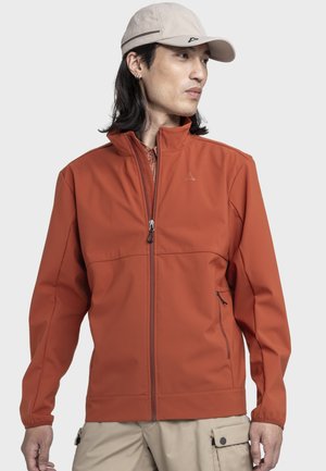 Rote Softshell-Jacke mit hohem Kragen, Reißverschluss vorne und Seitentaschen. Glatte Oberfläche, minimalistisches Design mit Logo auf der Brust.