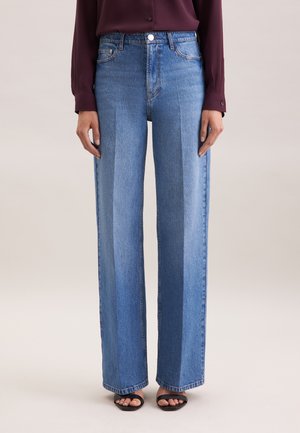 Jeans in denim azzurro chiaro a gamba larga con vita alta, cuciture accentuate e un classico design a cinque tasche. Abbinati a sandali neri.