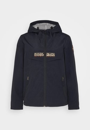 Tengeri vízálló dzseki kapucnival, elülső cipzárral és két oldalsó zsebből áll. A mellkasi logó és a kontrasztos varrási részletek jellemzik.