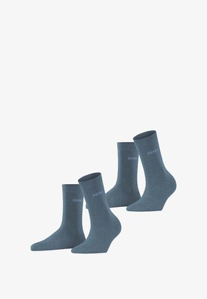 Ensemble de chaussettes en coton bleu, avec des bords côtelés et un logo. Texture lisse et design mi-mollet. Quatre paires présentées, alignées à différents angles.