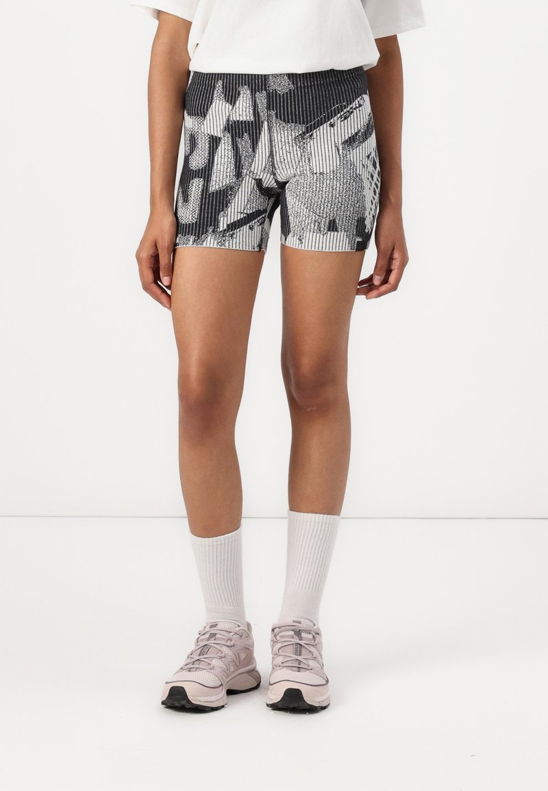 Höga, åtsittande shorts i svart och vitt mönstrat stickat. Har vertikala ränder, texturerad design och ett elastiskt midjeband.