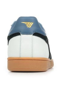 Sneaker bianca e nera con accenti blu, dotata di un logo dorato sul tallone, superiore testurizzato e suola in gomma.