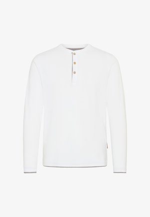 Camisa blanca de manga larga con cuello redondo, placket de tres botones y ribete gris contrastante en los puños y el dobladillo.