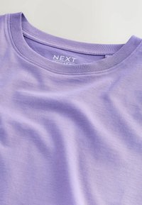 T-shirt en coton lavande à col rond avec étiquette de la marque « NEXT » et étiquette de coupe régulière à l'intérieur de l'encolure sur un fond clair.