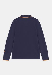 Dlouhý rukáv navy modrá polo košile s žlutým akcentem na límci a manžetách. Vyznačuje se hladkou texturou a klasickým střihem.