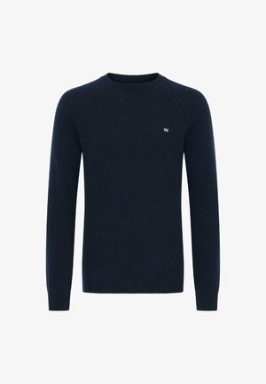 Tums zilā ribota džemperis ar garām piedurknēm un apaļu kakla izgriezumu; ar nelielu emblēmu uz krūtīm. Strukturēts dzijas materiāls.