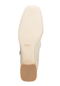 Suola di scarpa in pelle beige con finitura liscia, forma rettangolare e tacco a blocco marrone chiaro. Il testo impresso recita "VERO CUOIO MADE IN ITALY."