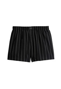 Boxers negros con finas rayas blancas, cinturilla elástica, cierre de botón y suave textura de tela. Presenta una etiqueta en la cintura.