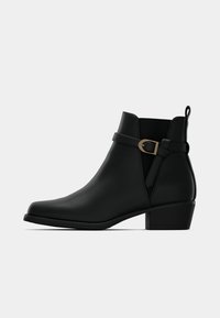 Melnas ādas potītes zābaki ar zemu bloku papēdi, sānu elastīgu paneļu un dekoratīvu siksniņu ar misiņa sprādzi uz ārējās puses.