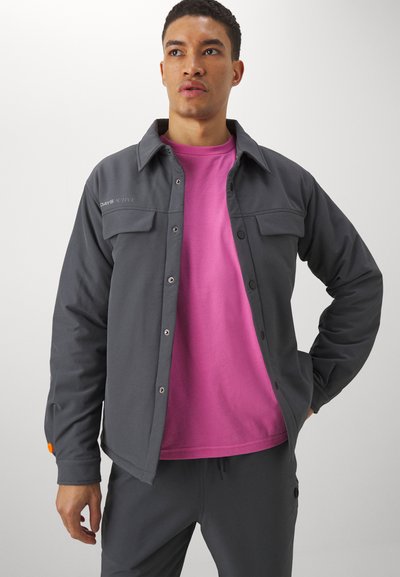 Gray button-up jacket with two front pockets and orange accent on the sleeve, layered over a pink t-shirt. Smooth fabric texture.